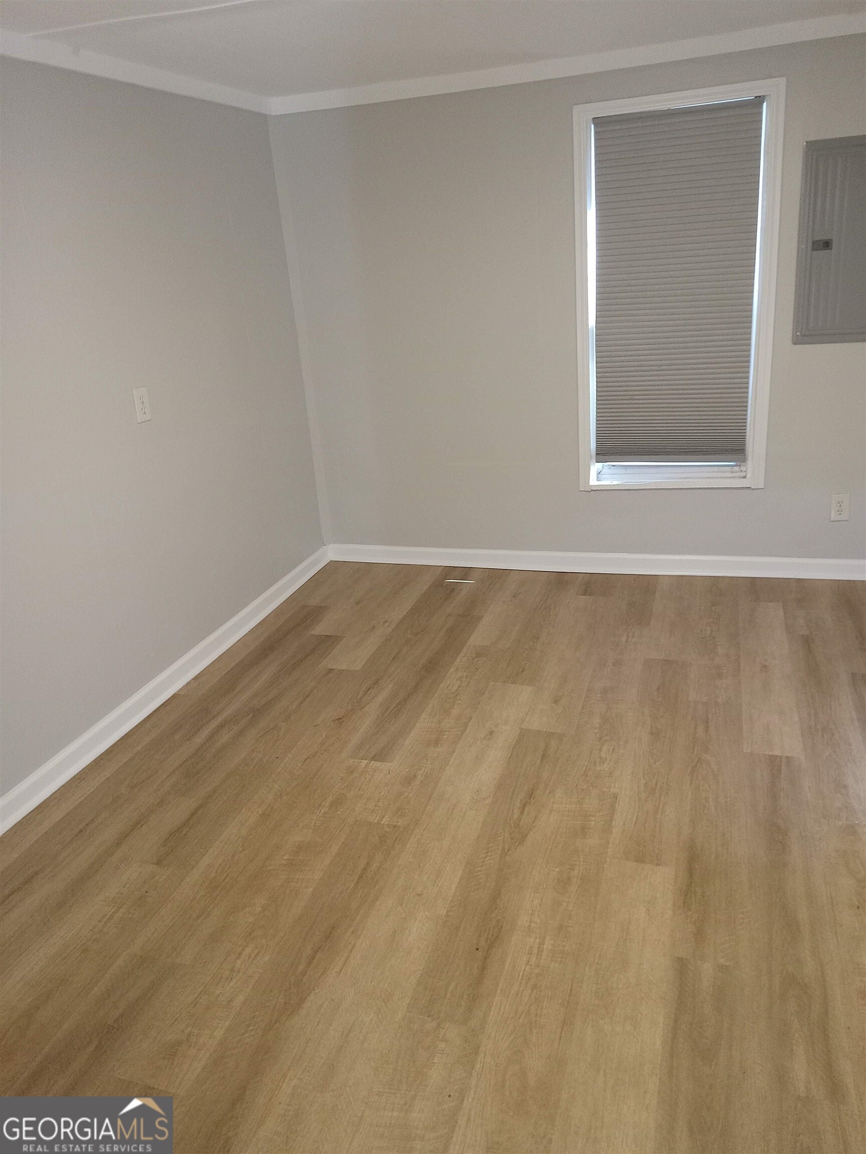 1186 Eastview Road Northeast Conyers, GA 30012 - Photo 14 of 20 a view of an empty room with wooden floor and a window