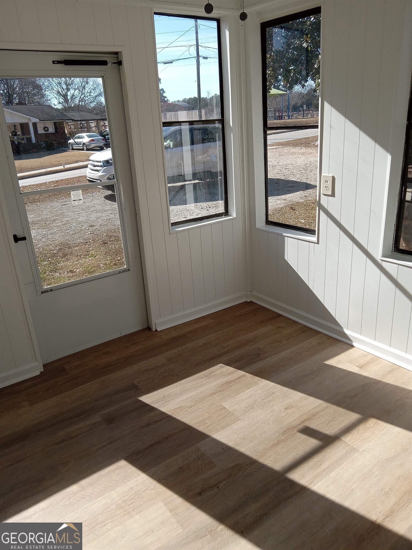 1186 Eastview Road Northeast Conyers, GA 30012 - Photo 4 of 20 a view of an empty room with wooden floor and a window