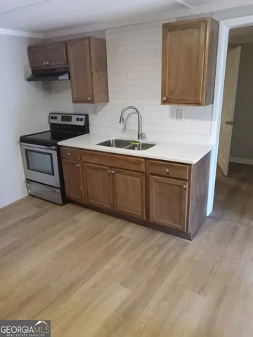 a kitchen with stainless steel appliances granite countertop a sink stove and cabinets