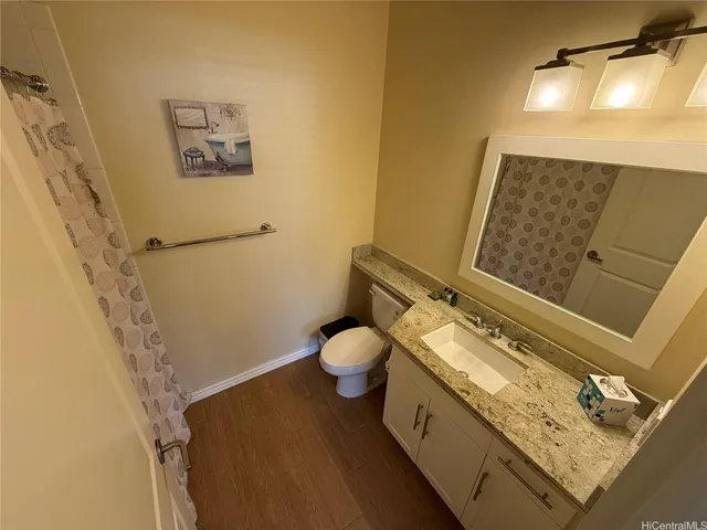 a bathroom with a granite countertop toilet and a shower
