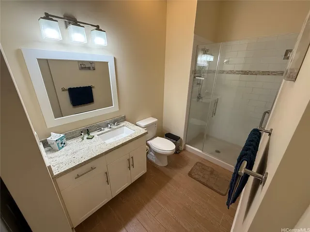 a bathroom with a sink a toilet a mirror and shower