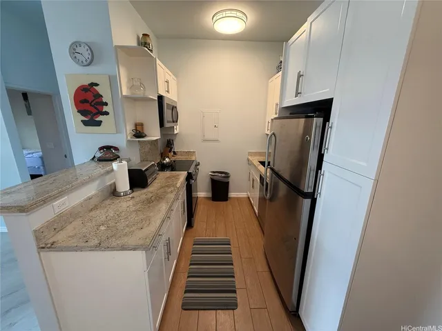 a view of kitchen with sink and refrigerator
