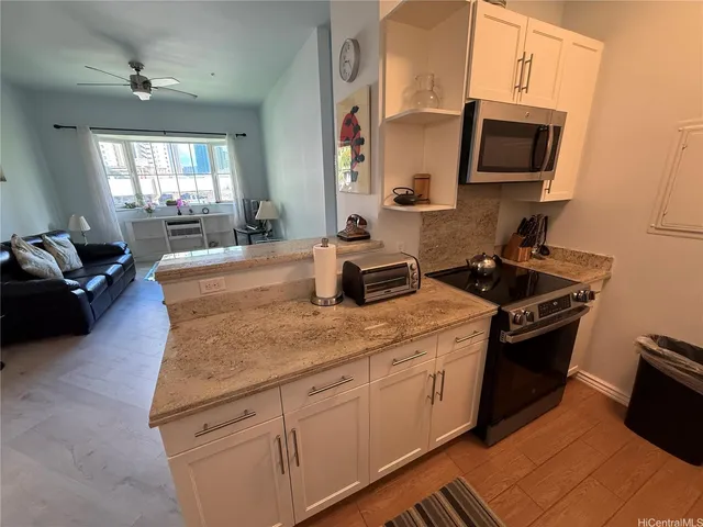 a kitchen with stainless steel appliances granite countertop a sink stove and microwave