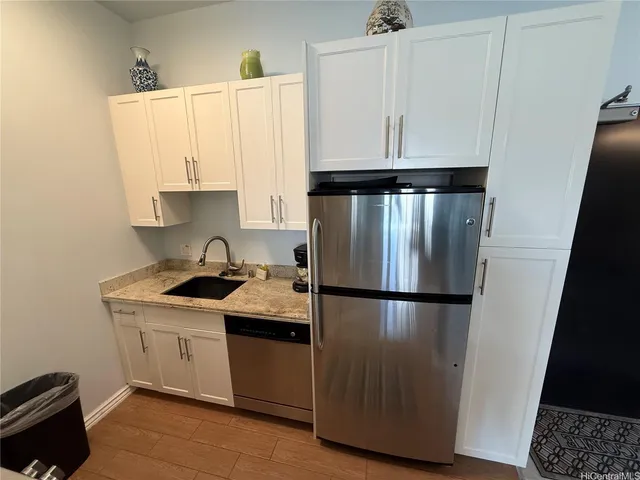 a kitchen with a sink a refrigerator and cabinets