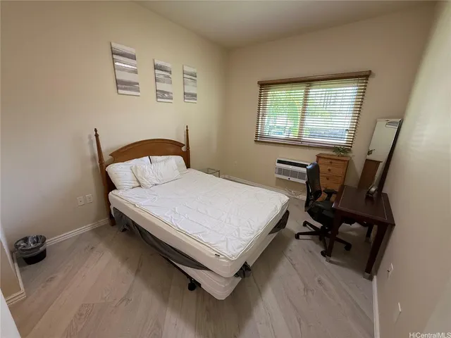a bedroom with a bed a desk and chair with window