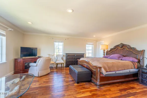 a spacious bedroom with a bed and wooden floor