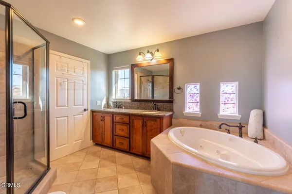 a spacious bathroom with a tub sink and mirror