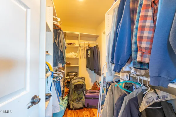 a view of walk in closet with clothes and shoes