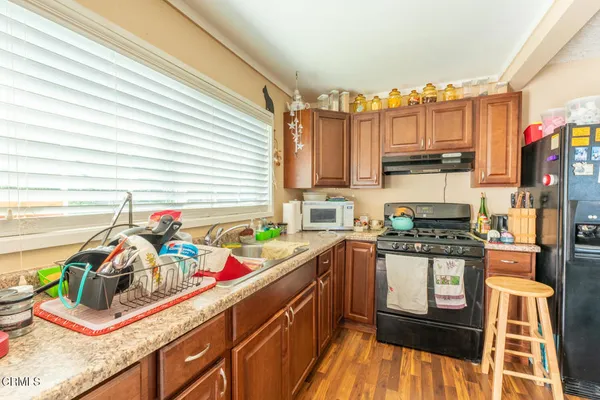 a kitchen filled with a stove a sink a refrigerator and a microwave