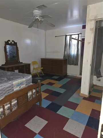 a bed sitting in a spacious bedroom next to a window