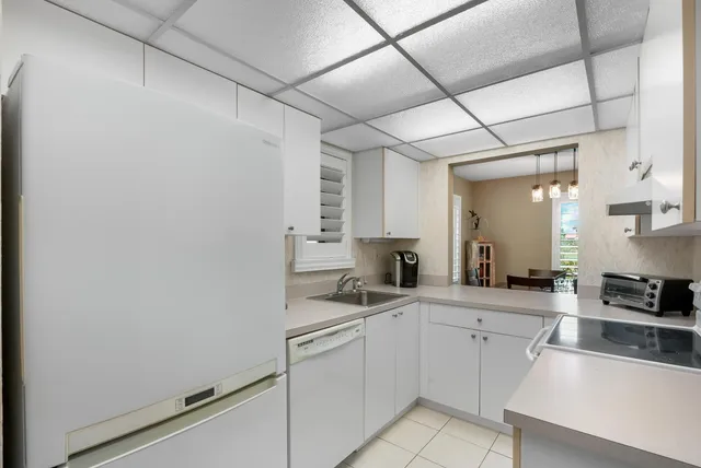 a kitchen with white cabinets and white appliances