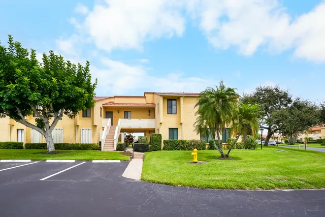 a front view of a house with a yard and trees