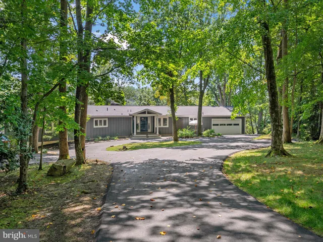 a backyard of a house with lots of green space and fountain
