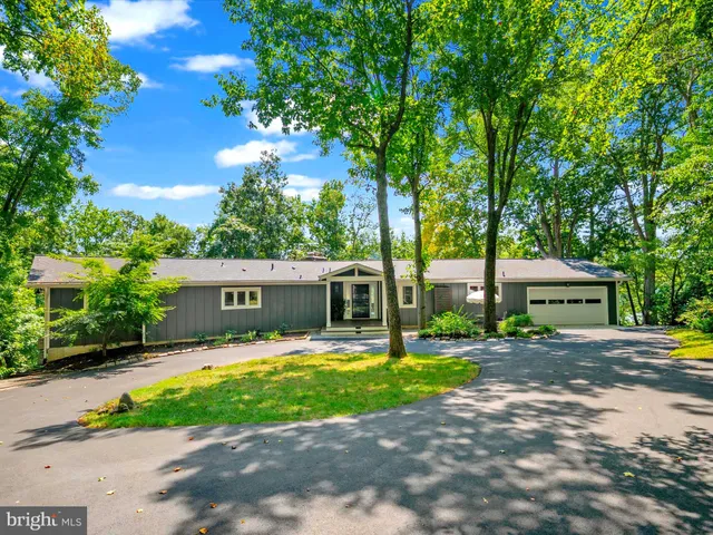 a kitchen with stainless steel appliances granite countertop a stove a refrigerator a kitchen island a stove a table and chairs with wooden floor