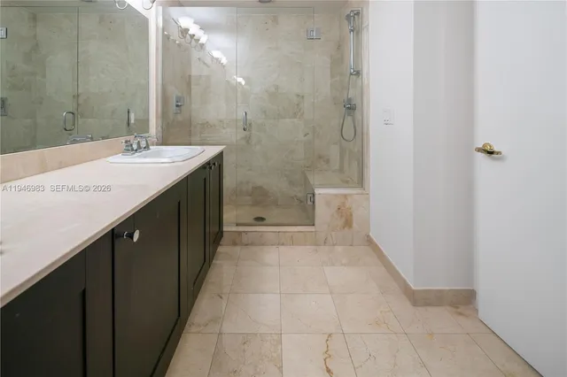 a bathroom with a granite countertop sink a toilet and shower
