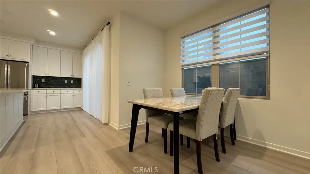 110 Sunnyside Irvine, CA 92620 - Photo 5 of 15 a kitchen with stainless steel appliances kitchen island granite countertop a table chairs sink and cabinets