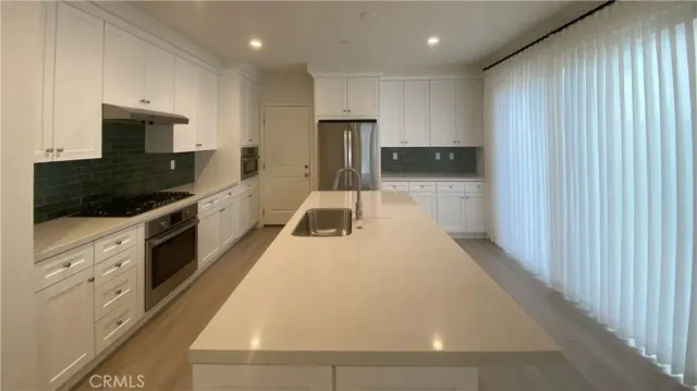 a kitchen with a sink and stainless steel appliances