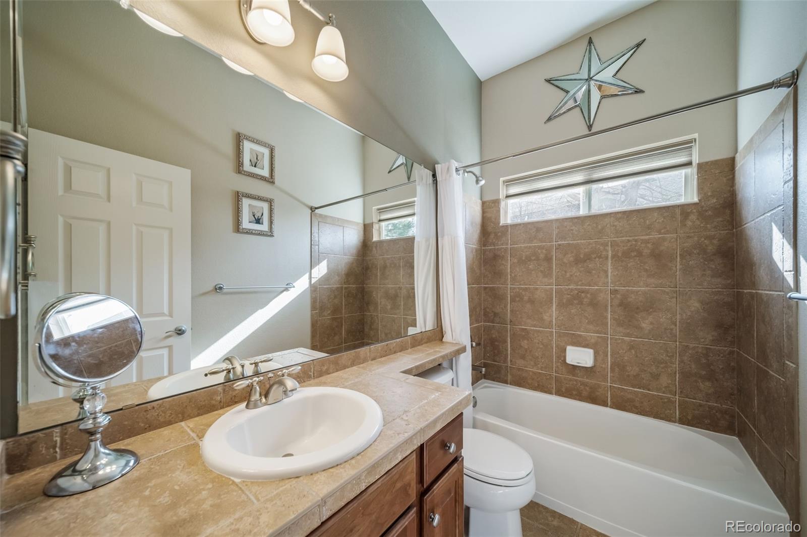 16598 Hitching Post Circle Parker, CO 80134 - Photo 27 of 50 a bathroom with a sink a toilet and a mirror