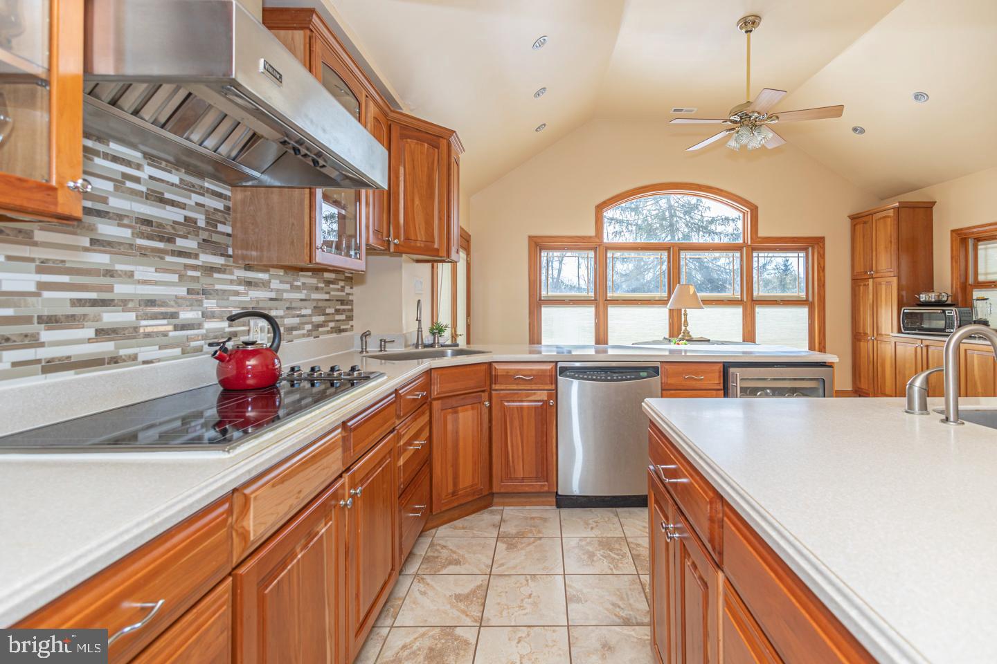 612 Double Woods Road Langhorne, PA 19047 - Photo 15 of 44 a kitchen with stainless steel appliances granite countertop a sink dishwasher a stove a dining table and chairs with wooden floor