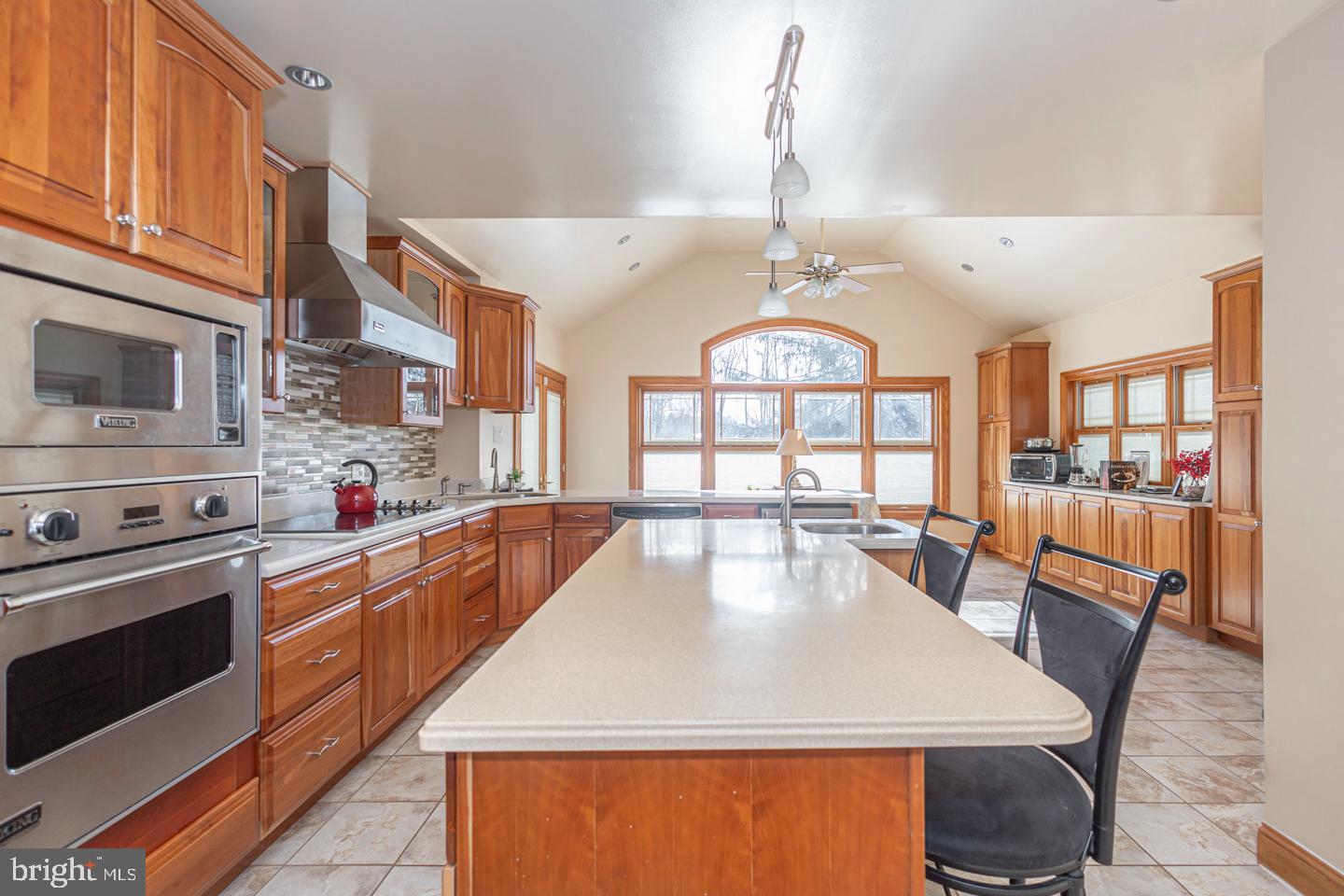 612 Double Woods Road Langhorne, PA 19047 - Photo 10 of 44 a large kitchen with stainless steel appliances granite countertop a stove a refrigerator a oven a dining table and chairs with wooden floor