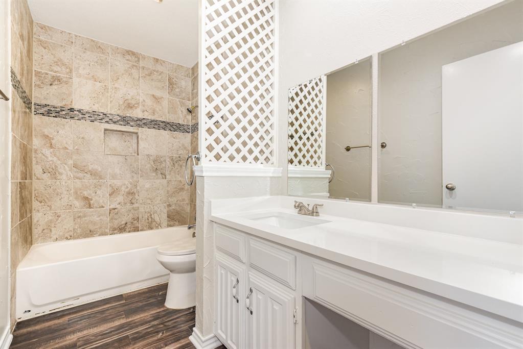 229 South Heartz Road Coppell, TX 75019 - Photo 16 of 19 Bathroom featuring vanity, shower / tub combination, and wood finished floors