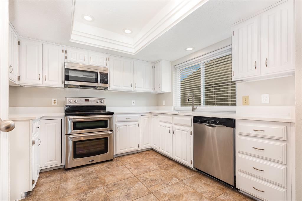 229 South Heartz Road Coppell, TX 75019 - Photo 9 of 19 Kitchen with appliances with stainless steel finishes, recessed lighting, white cabinets, light countertops, and a raised ceiling