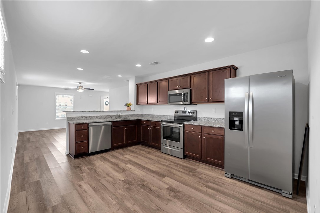 215 Royal Way Pendleton, SC 29670 - Photo 9 of 31 This open-concept kitchen features dark wood cabinetry, granite counters, and stainless steel appliances.