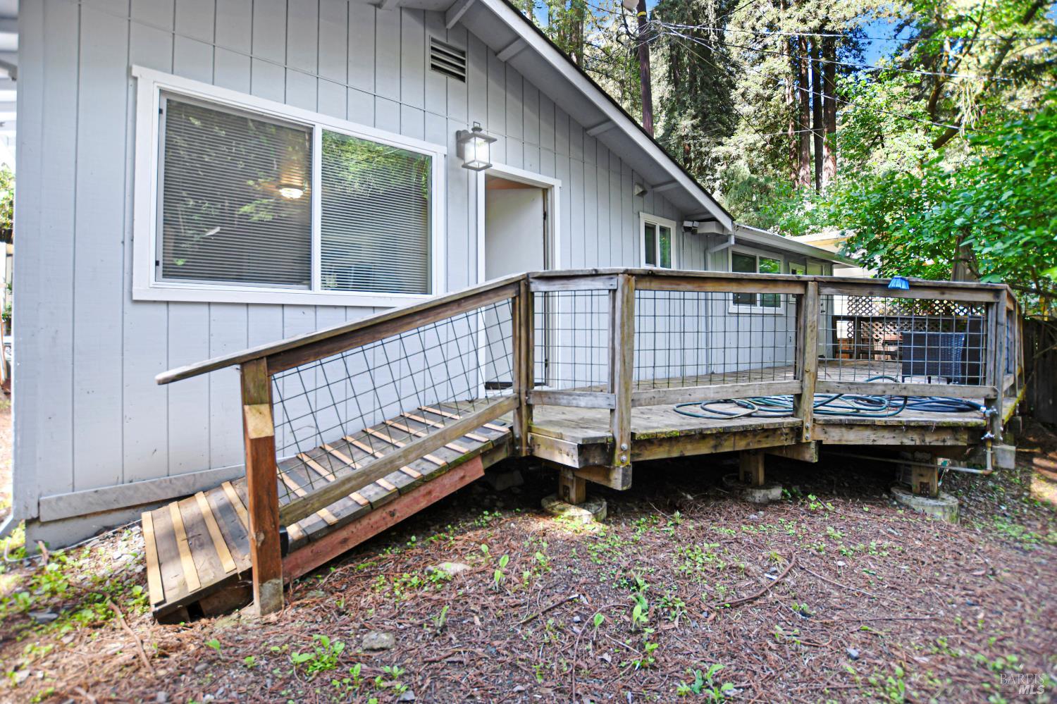 15289 Willow Road Guerneville, CA 95446 - Photo 16 of 22 a view of a house with a wooden deck and a backyard