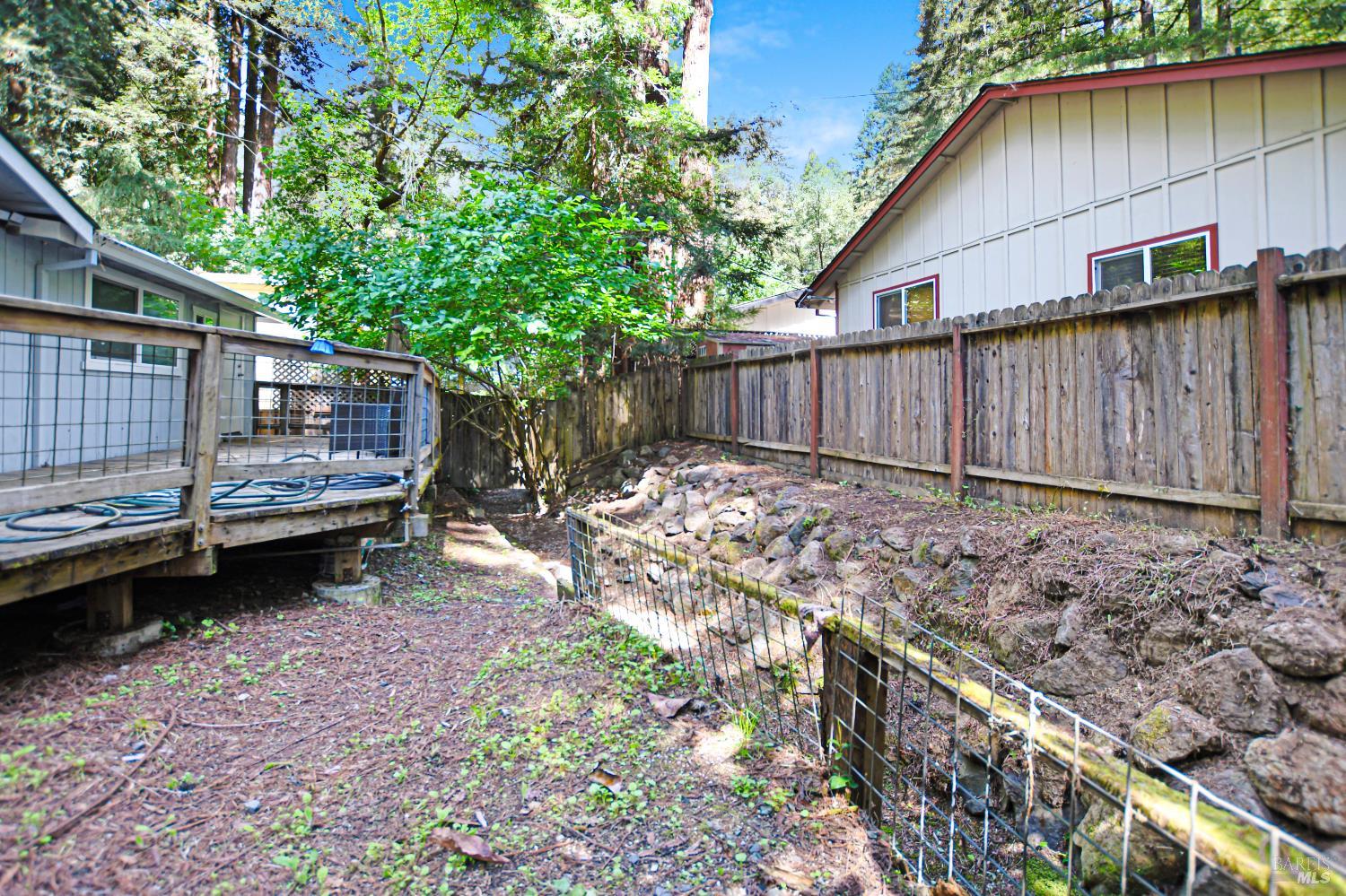 15289 Willow Road Guerneville, CA 95446 - Photo 17 of 22 a view of a backyard with a large tree and wooden fence