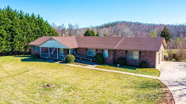 a view of house with yard and swimming pool