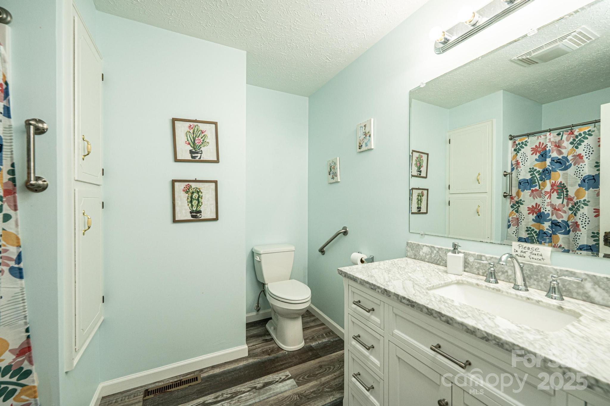 1221 Connelly Springs Road Lenoir, NC 28645 - Photo 19 of 42 a bathroom with a granite countertop sink mirror vanity and toilet