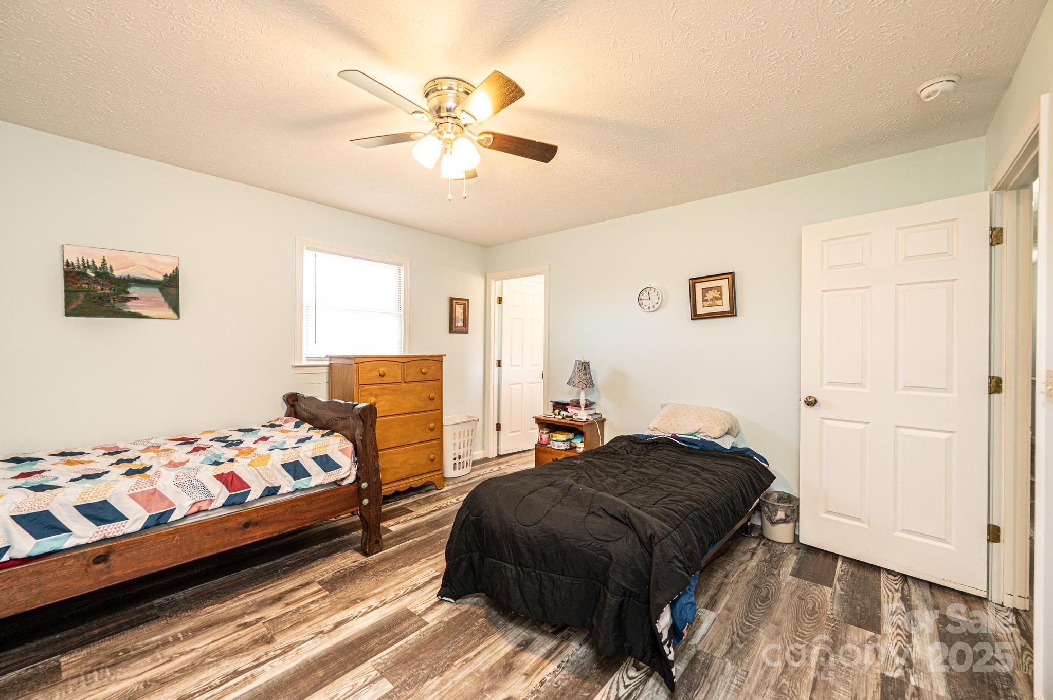 1221 Connelly Springs Road Lenoir, NC 28645 - Photo 21 of 42 a bedroom with a bed and a chandelier