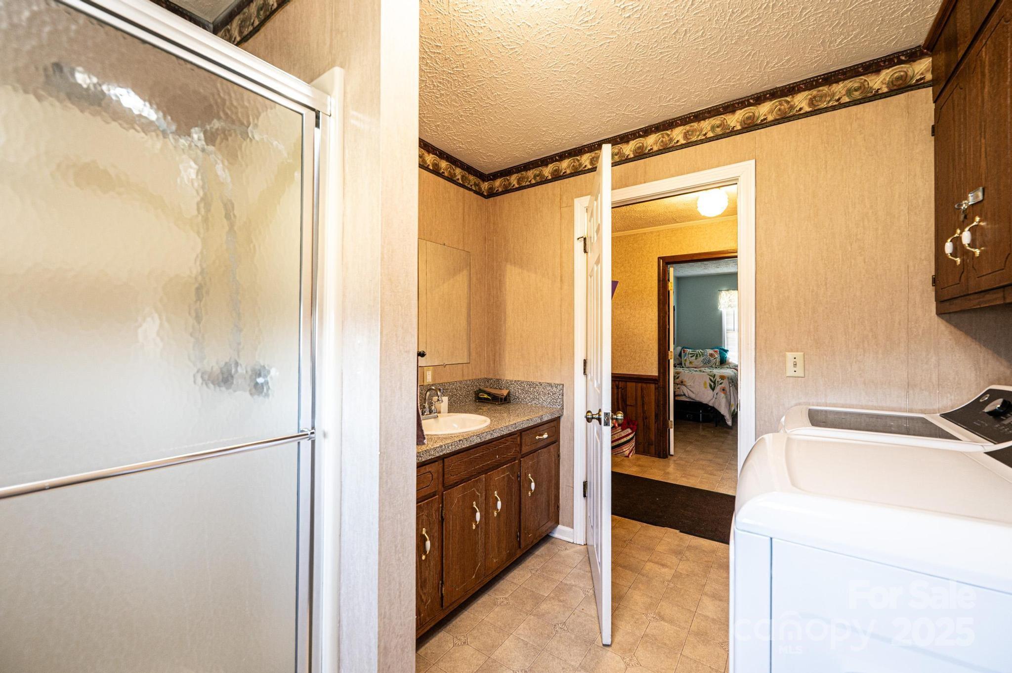 1221 Connelly Springs Road Lenoir, NC 28645 - Photo 26 of 42 a en suite bathroom with a sink a mirror and a shower