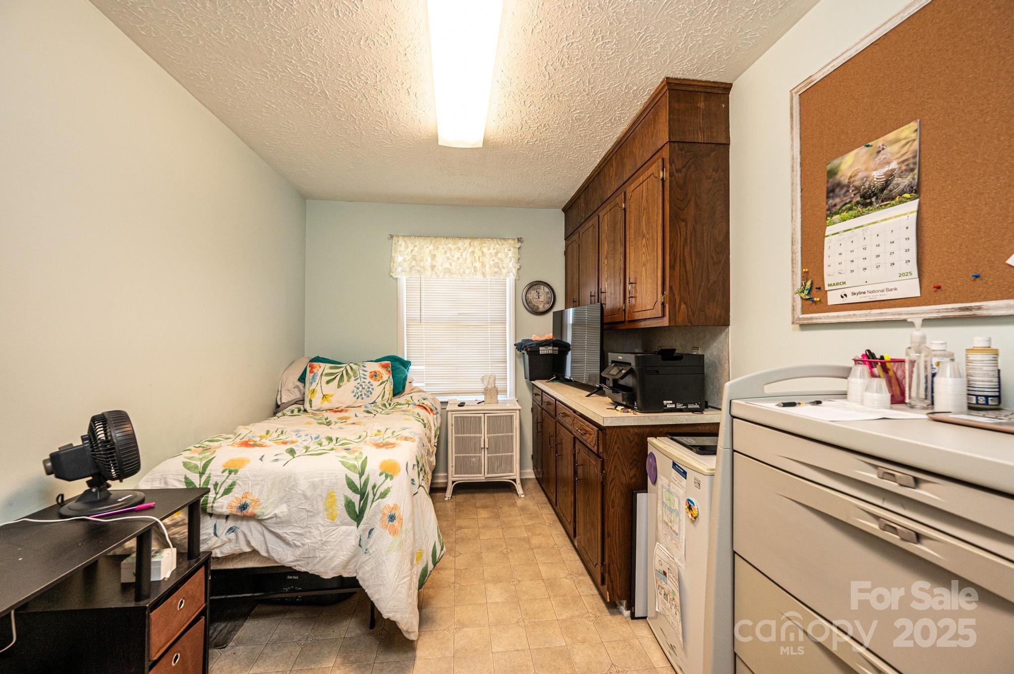 1221 Connelly Springs Road Lenoir, NC 28645 - Photo 27 of 42 a bedroom with a bed and wooden cabinets