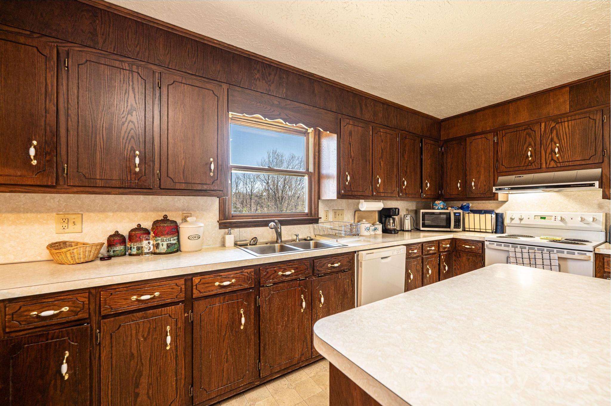 1221 Connelly Springs Road Lenoir, NC 28645 - Photo 32 of 42 a kitchen with a sink a stove and cabinets