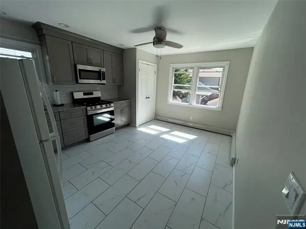 a kitchen with stainless steel appliances a refrigerator a stove a microwave and cabinets