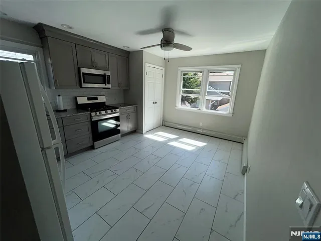 a kitchen with stainless steel appliances a refrigerator a stove a microwave and cabinets