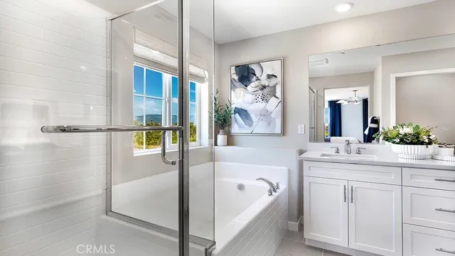 a spacious bathroom with a tub sink and mirror