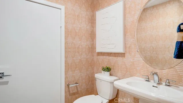 a bathroom with a sink a toilet and mirror