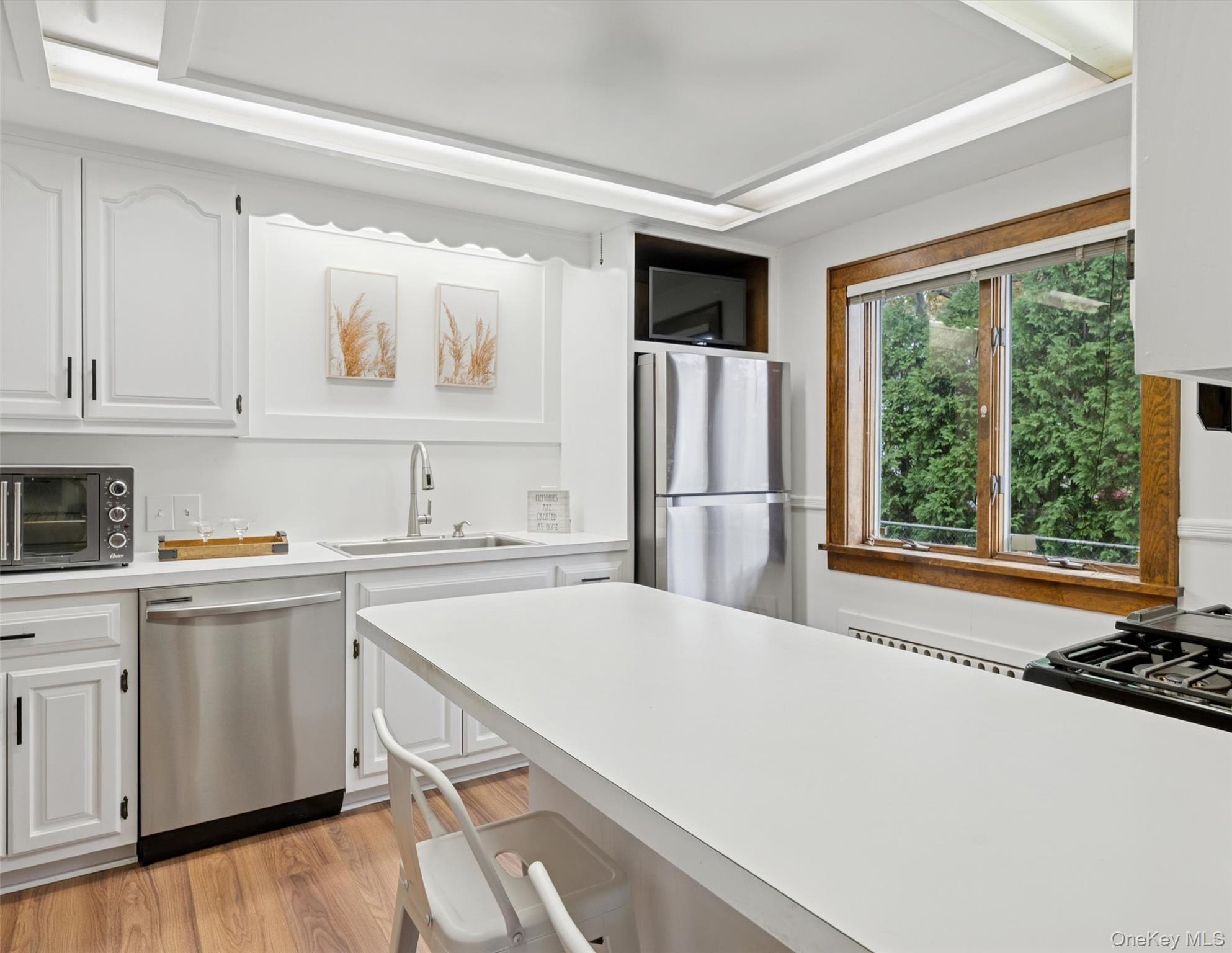 148 Woodhull Avenue Riverside, NY 11901 - Photo 12 of 20 a kitchen with a refrigerator a stove a sink and a window with wooden floor