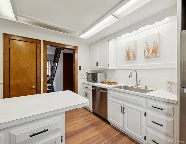a kitchen with a sink cabinets and wooden floor