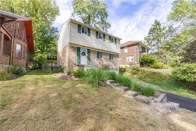 a front view of a house with a garden