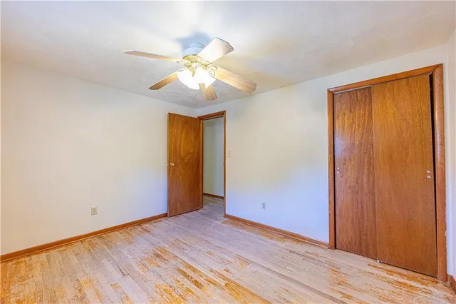 an empty room with wooden floor and closet area