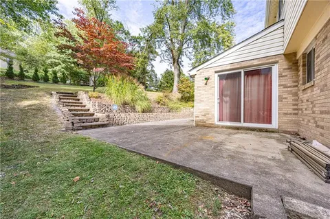 a view of a house with backyard and trees