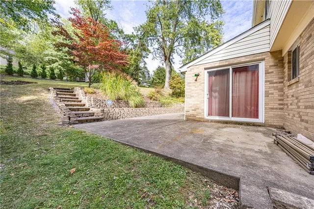 a view of a house with backyard and trees