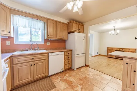 a kitchen with a refrigerator sink and cabinets