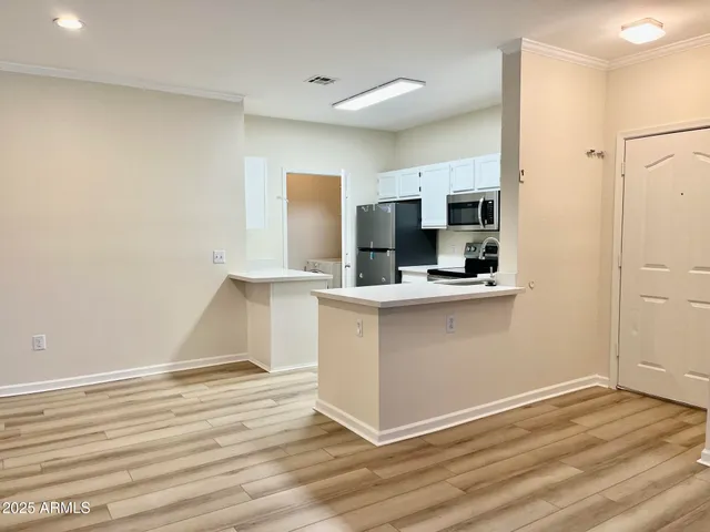 a kitchen with granite countertop white cabinets and refrigerator