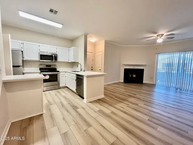 a view of kitchen with stainless steel appliances granite countertop a stove top oven a sink and a refrigerator