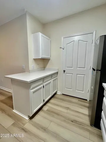 a kitchen with white cabinets and sink