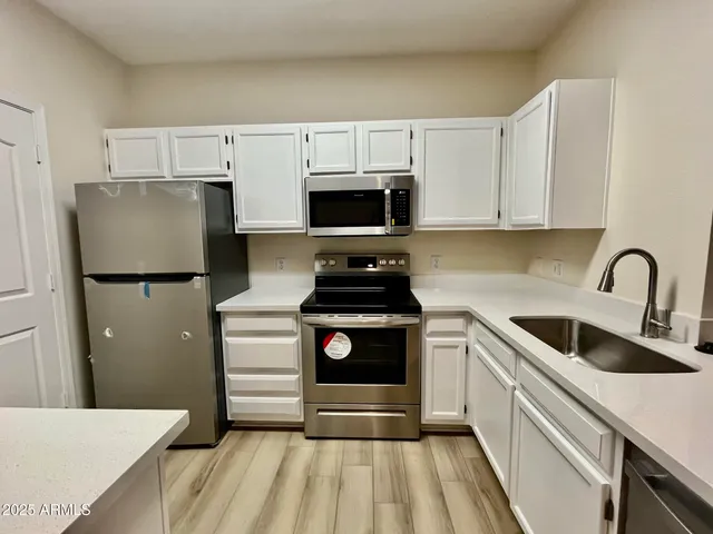 a kitchen with a refrigerator and a stove top oven